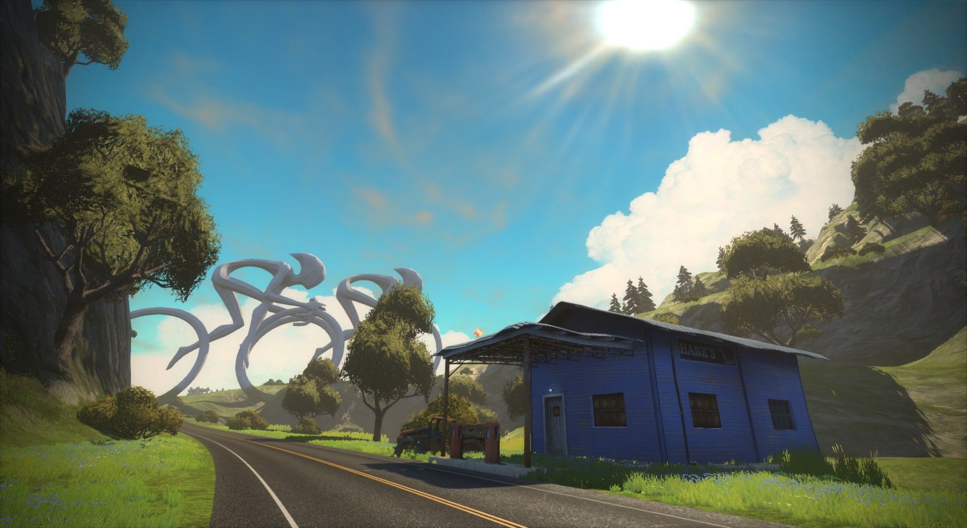 A scenic landscape featuring a blue building on the roadside, with green hills and trees surrounding it. In the background, abstract sculptures resembling large rings are visible against a bright blue sky with fluffy clouds. The sun is shining brightly in the sky.