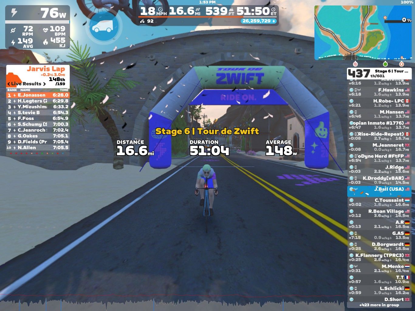 A screenshot of a cycling event in the Zwift virtual environment. The image shows a cyclist approaching a colorful archway labeled 