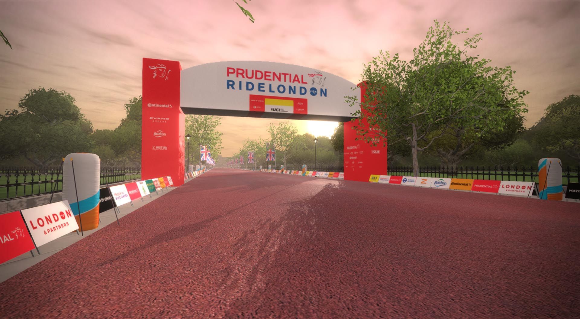 A virtual image of the Prudential RideLondon event in Zwift, featuring a wide race course with a red finish arch. The path is lined with banners and trees, under a sunset sky.