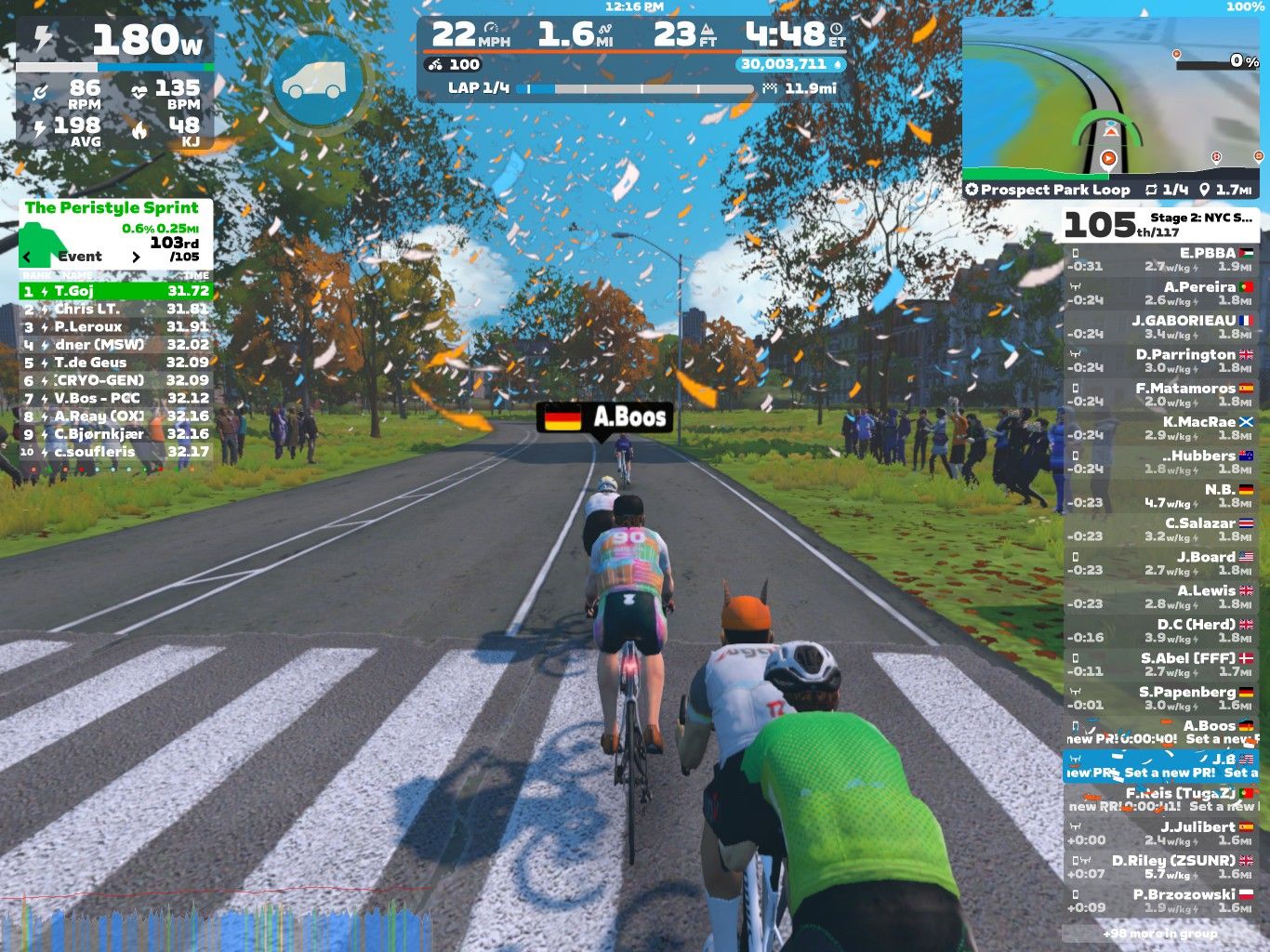 A digital cycling race scene from Zwift, showing three cyclists racing on a tree-lined road with autumn leaves. The screen displays rider statistics, including speed, distance, and power output, along with a leaderboard and map of the course.
